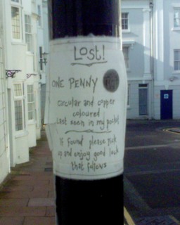 Poster stuck to a lamp-post