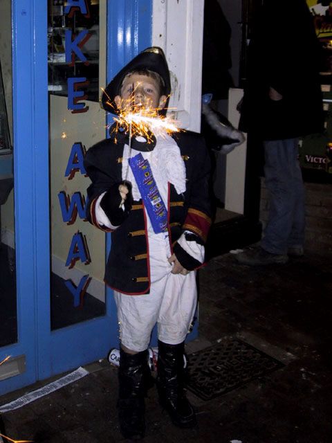 A boy in traditional dress with a sparkler